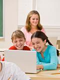 Girls using laptop in classroom