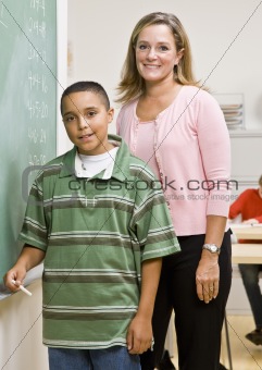 Teacher helping student at blackboard