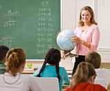 Teacher explaining globe to students