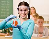 Student holding beaker of liquid in classroom