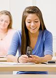 Student text messaging on cell phone in classroom
