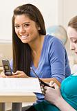 Students text messaging on cell phones