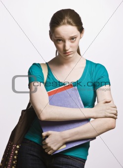 Sad student carrying book bag and notebook