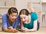 Teenage girls text messaging on cell phone