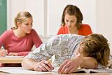 Student sleeping at desk in classroom