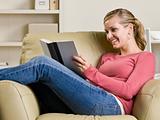 Teenage girl reading book in chair