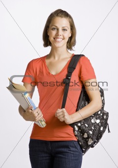Student carrying backpack and books