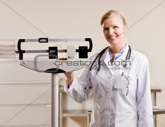 Doctor standing with weighing scales