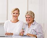 Senior woman writing checks with daughterÕs help