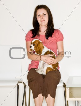 Woman holding dog in waiting room