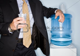 Businessman drinking water from water cooler
