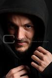 Portrait of young man hiding in black hood