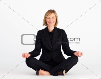 Mature businesswoman meditating on the floor