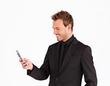Smiling businessman writing a message with a mobile phone