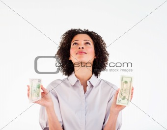 Brunette businesswoman holding dollars and looking upwards
