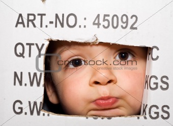 Bored kid peeking out from a cardboard box