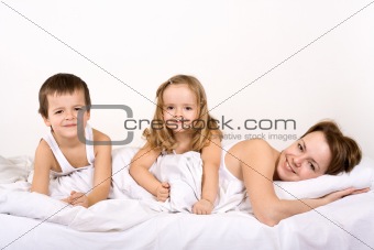Happy people posing for a family portrait in bed