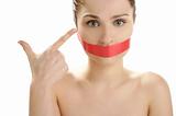Beautiful woman with red tape on mouth portrait
