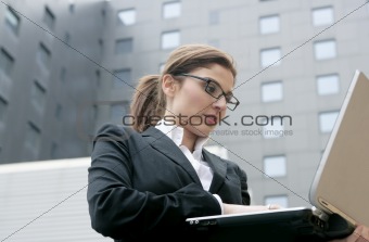 Businesswoman with laptop computer on the city
