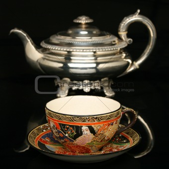 Silver teapot and an antique chinese cup of tea