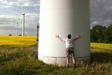 Man embraces a Windmill in front of a rape field