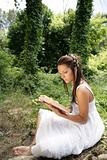 Beautiful woman reading a book in forest, nature