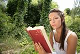 Beautiful woman reading a book in forest, nature