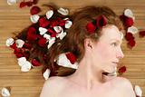 Redhead beautiful woman, rose petals on hair
