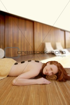 Beautiful woman relax black stones on back