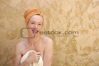Beautiful woman sitting with towel on bath
