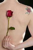 Nude woman back with rose and flower tatoo