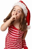 Little girl in santa hat gesturing peace and quiet