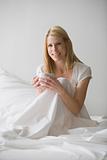 Woman Sitting in Bed With Coffee Cup