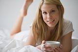 Woman In Bed With a Cup of Coffee