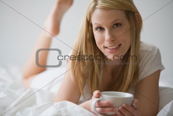 Woman In Bed With a Cup of Coffee