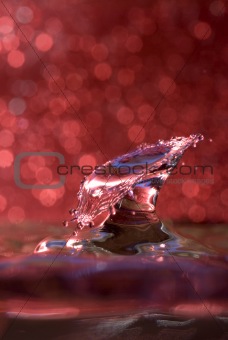 Water drop collision against a red background