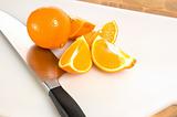 Fresh cut oranges on cutting board with knife