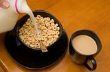 Breakfast consisting of cereal with milk and coffee with cream