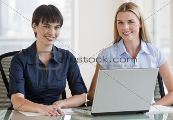 Two women working on a computer together