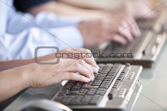 People's hands typing on computer