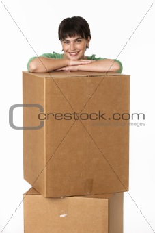 Brunette posing while resting her arms on a cardboard box