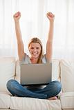 Young woman with a laptop cheering