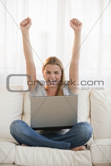 Young woman with a laptop cheering