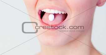 Woman with a pill in her mouth 