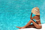 Woman in hat relaxing beside the pool
