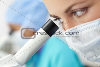 Woman Doctor or Scientist Using a Microscope In Laboratory