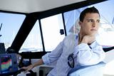 Young handsome man on a yacht boat interior