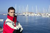 Handsome boy on harbor with red marine coat