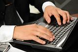 Hands of the businessman above the keyboard laptop