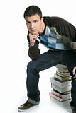 Young student boy sitting over stack books